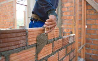 Worker Building Masonry House Wall With Bricks